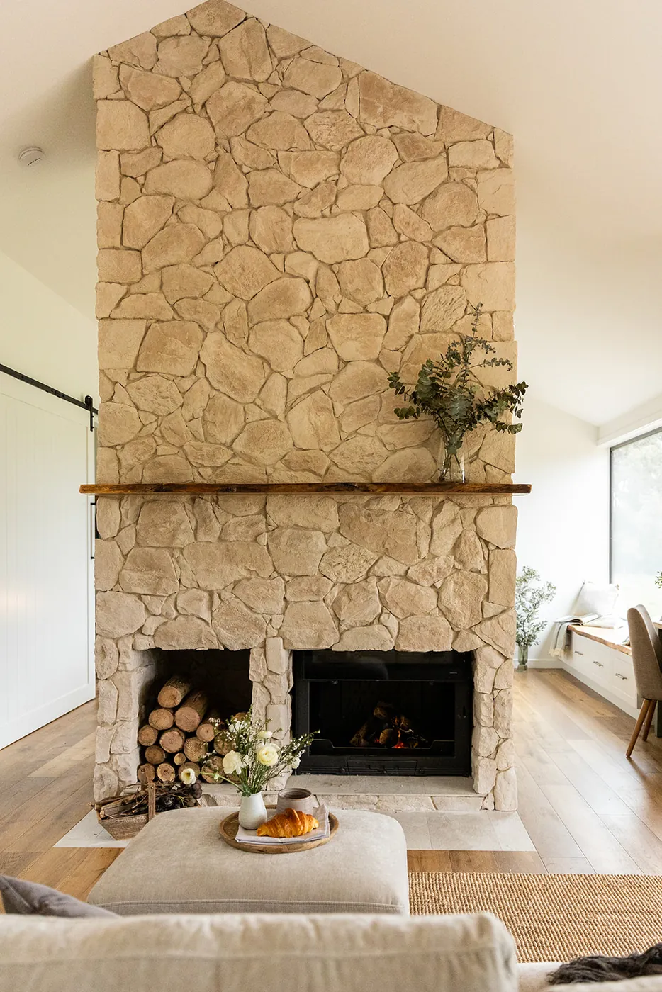 The stone fireplace at Forever Held, rising to the cathedral ceiling