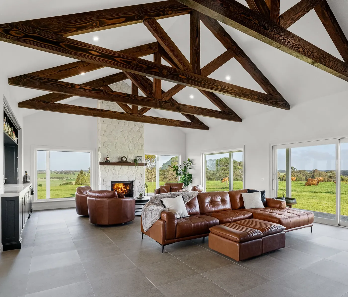 Grand living room with exposed timber trusses and stone fireplace