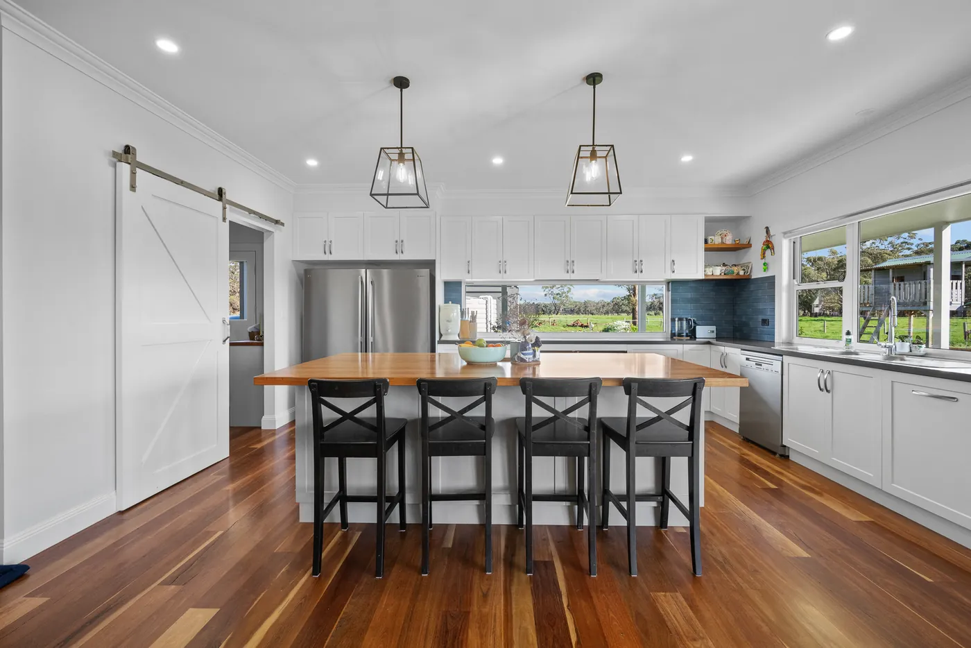 The kitchen at Laang Farmhouse, with a timber-topped island and white shaker cabinetry